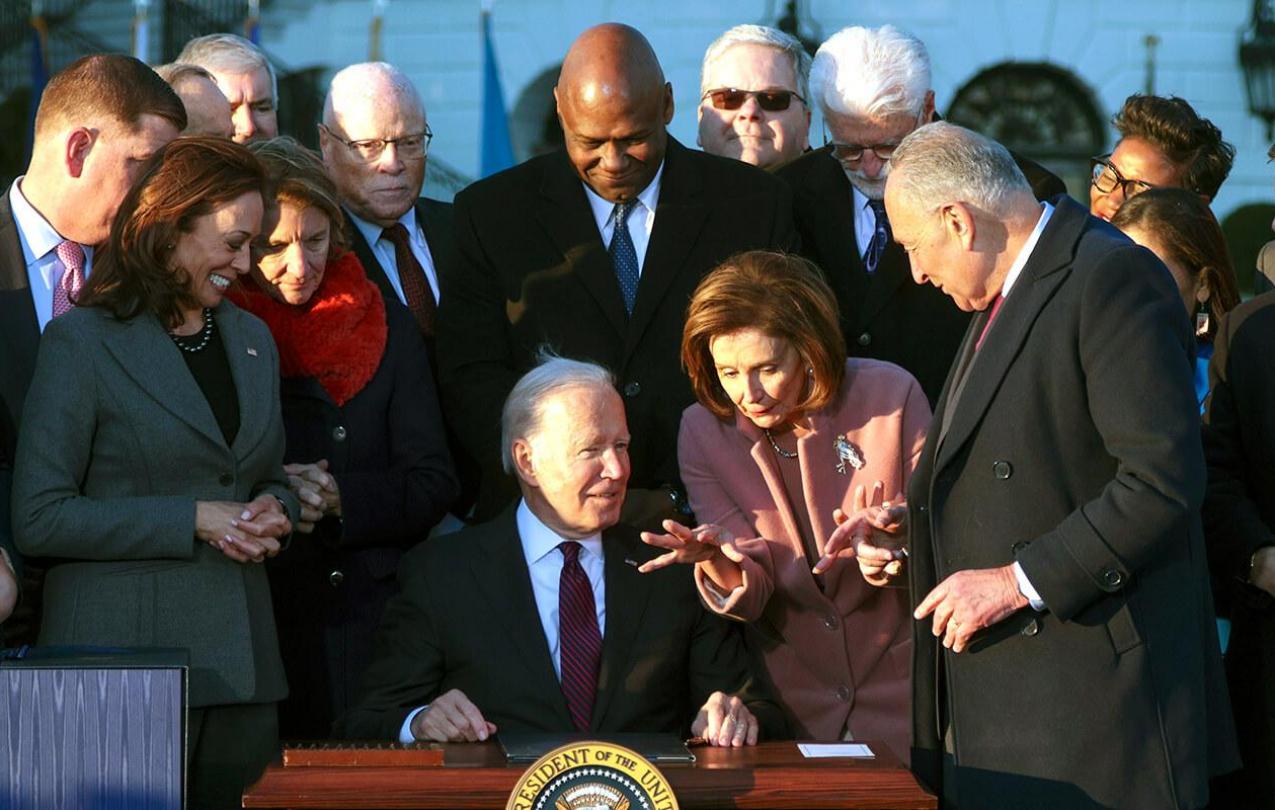 President Joe Biden signs the infrastructure bill at the White House as he is surrounded by lawmakers, Cabinet members and other allies, including AFSCME President Lee Saunders. (Photo by Alex Wong/Getty Images)